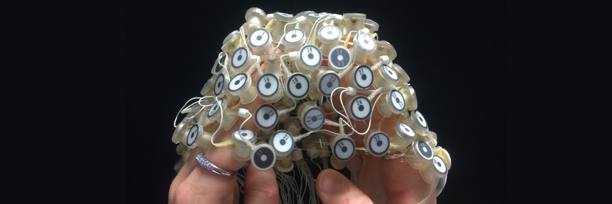 Mani che mostrano un cappuccio di biofeedback di attività dell'onda celebrale EEG